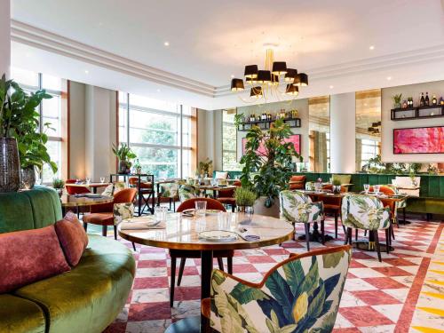 a restaurant with tables and chairs and a lobby at Sofitel Luxembourg Europe in Luxembourg