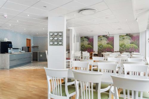 a dining room with white tables and white chairs at Best Western Hotel Esplanade in Västerås