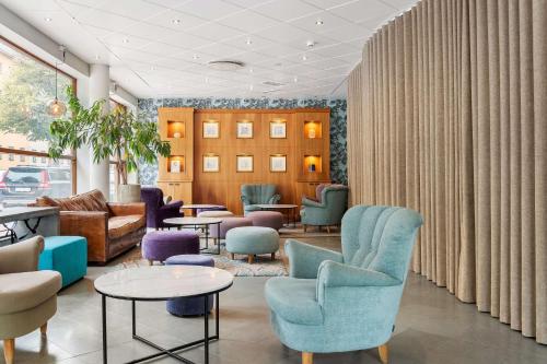 a waiting room with blue chairs and tables at Best Western Hotel Esplanade in Västerås