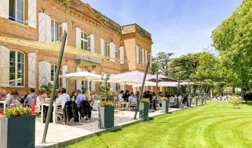 a group of people sitting at tables outside of a building at Best Western Premier Le Domaine de Montjoie in Ramonville-Saint-Agne