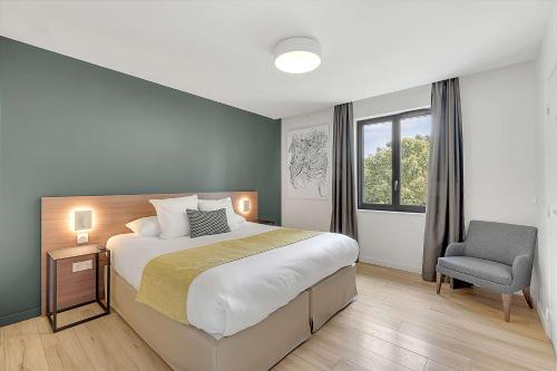 um quarto com uma cama grande e uma cadeira em Domaine de Montjoie - Toulouse - BW Premier Collection em Ramonville-Saint-Agne