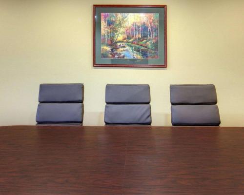 two chairs in a waiting room with a table and a painting at Comfort Inn West Monroe near Sports & Events Center in West Monroe