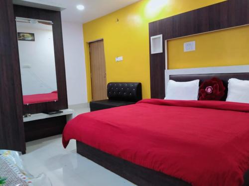 een slaapkamer met een groot rood bed en een stoel bij Hotel Firdous Palace, Surajpur Chhattisgarh 