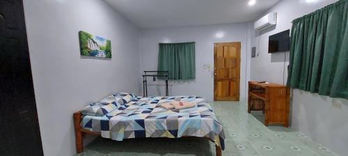 a bedroom with a bed and a wooden door at Genna's Tourist Inn Santa Fe in Bantayan Island