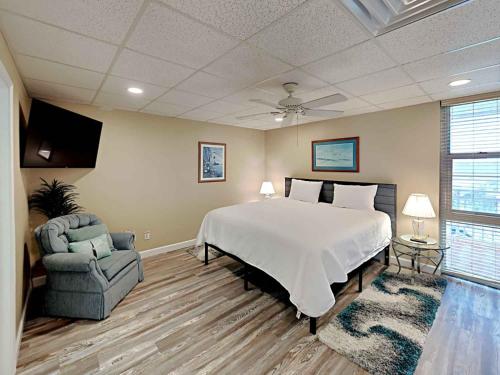 a bedroom with a bed and a couch and a chair at Sans Souci #605 in Pensacola Beach