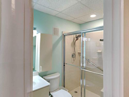 a bathroom with a toilet and a glass shower at Sans Souci #605 in Pensacola Beach
