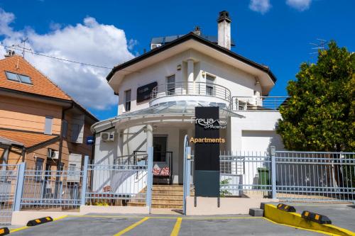 ein weißes Haus mit einem Zaun davor in der Unterkunft Freya SPA Apartments in Niš