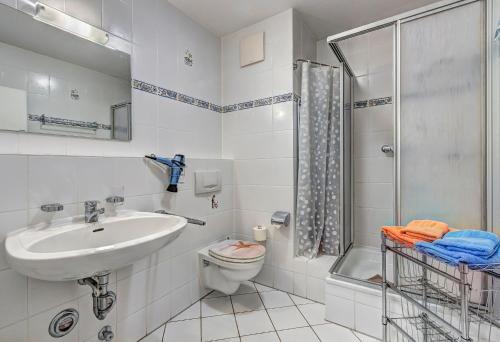 een badkamer met een wastafel, een toilet en een douche bij Villa Regina Maris Fewo Lachmöwe in Bansin