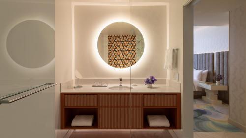 a bathroom with a sink and a mirror at Lake Nona Wave Hotel in Orlando