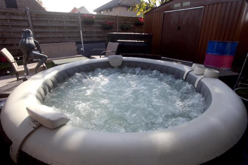 a hot tub in a backyard with a bird statue at Chambre d'hôte Blankenberge in Blankenberge