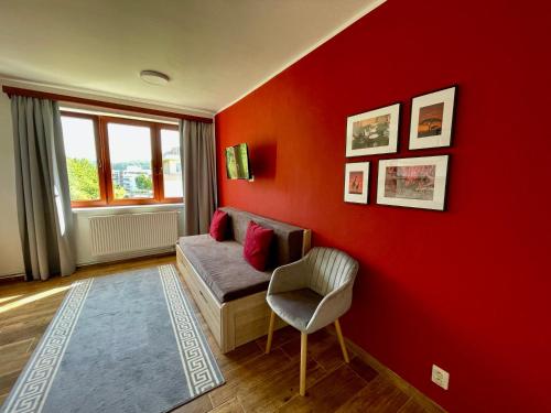 a red room with a couch and a chair at Penzion U Přehrady in Luhačovice