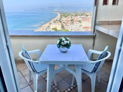 a table with chairs and a vase of flowers on a balcony at Florenza Residence in Sperlonga