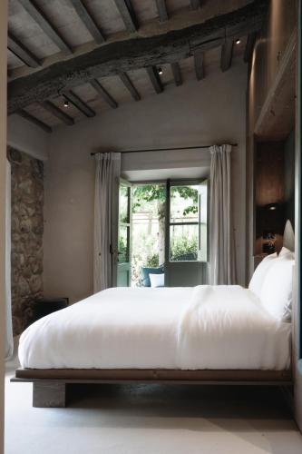 a large white bed in a bedroom with a window at Vocabolo Moscatelli in Calzolaro