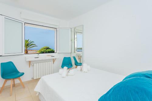 una camera da letto con due sedie e un letto e una finestra di Binicasal a Sant Lluís