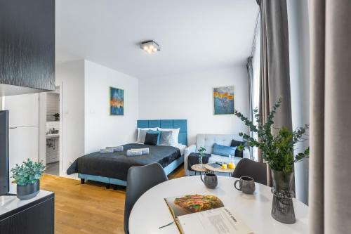 a bedroom and a living room with a bed and a table at Emihouse CityVibe Apartments in Rzeszów