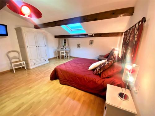 ein Schlafzimmer mit einem roten Bett in einem Zimmer in der Unterkunft Gîte et chambres d'hôtes LE MERCOIRE in Aubenas
