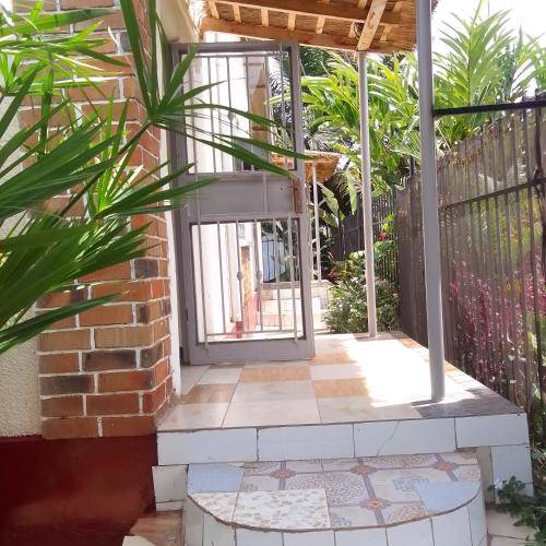 an open door to a courtyard with plants at Dream jet suites in Entebbe
