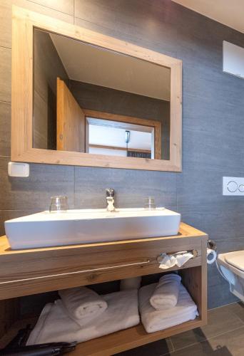 a bathroom with a sink and a mirror at Das Grünholz Aparthotel in Mühlbach am Hochkönig