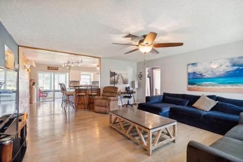 uma sala de estar com um sofá azul e uma mesa em The Lake Home - PET FRIENDLY! A Beautiful Oasis In The Heart Of Florida! home em Haines City