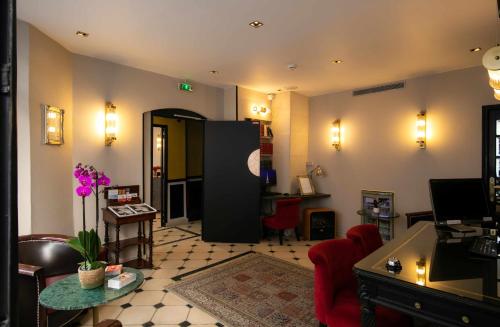 a living room with a red chair and a black refrigerator at Hôtel Eiffel Rive Gauche in Paris