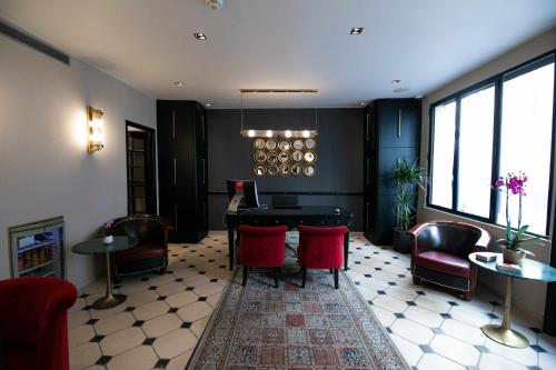 a waiting room with red chairs and a table at Hôtel Eiffel Rive Gauche in Paris