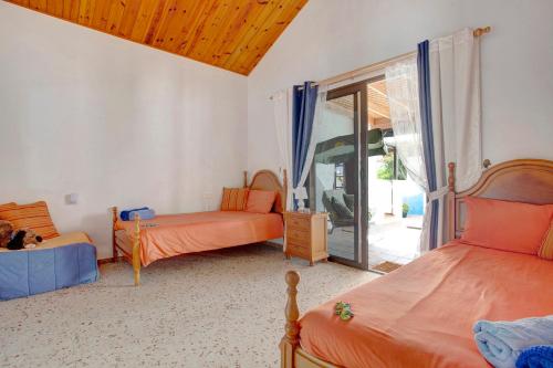 a bedroom with two beds and a sliding glass door at Casa Albryna Lanzarote in Tahiche