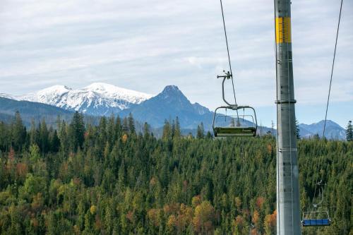 a gondola ride in the mountains with snow at Górski Domek DeLux in Male Ciche
