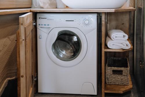 a washer and dryer under a sink in a bathroom at Górski Domek DeLux in Male Ciche