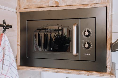 a microwave oven on a wall in a kitchen at Górski Domek DeLux in Male Ciche