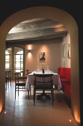 a dining room with a table and a red couch at Vocabolo Moscatelli in Calzolaro