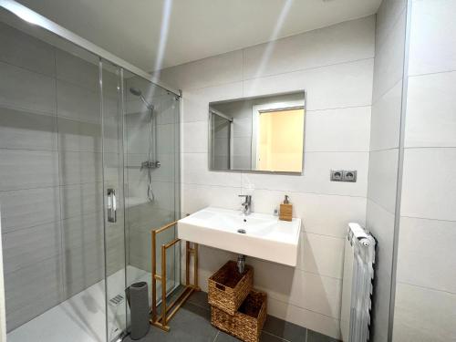 a bathroom with a sink and a shower at Espot Cowork & Apartments - L'Amfitriona in Espot