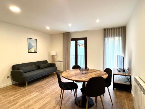 sala de estar con sofá, mesa y sillas en Espot Cowork & Apartments en Espot