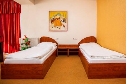 a room with two beds in a room at Hotel Boss in Žilina
