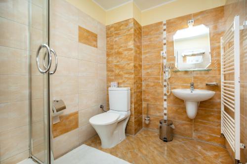 a bathroom with a toilet and a sink and a shower at Hotel Boss in Žilina