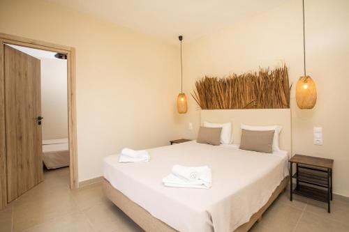 a bedroom with a white bed with two towels on it at Atma Beach Rooms & Suites in Faliraki