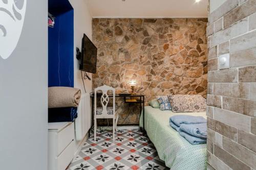 ein Schlafzimmer mit einem Bett und einer Steinmauer in der Unterkunft Fernando Lemos Estúdio Lisboa in Lissabon