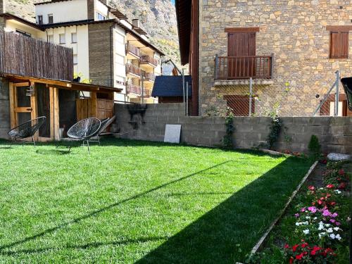 a backyard with a lawn with chairs and flowers at Espot Cowork & Apartments in Espot