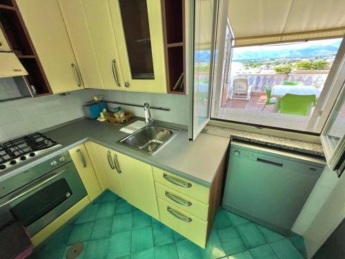a kitchen with a sink and a stove and a window at Florenza Residence in Sperlonga