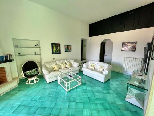 a living room with two white couches and a green floor at Florenza Residence in Sperlonga