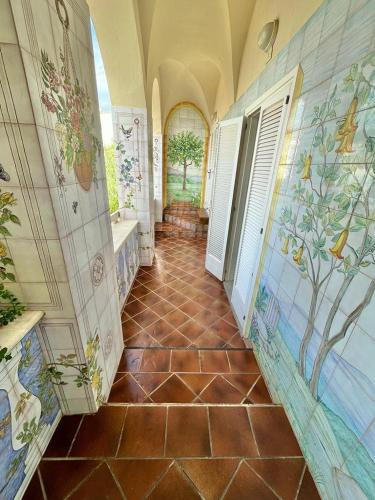a bathroom with a tiled floor and a hallway at Florenza Residence in Sperlonga