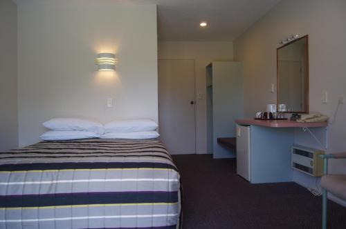Habitación de hotel con cama y lavabo en Heritage Park Lodge en Haast