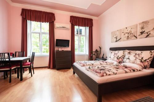 a bedroom with a bed and a dining room with a table at Pension Primavera in Vienna