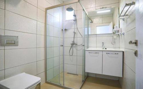 a bathroom with a shower and a toilet and a sink at Queen Victoria Suit Apart OTEL in Bodrum City