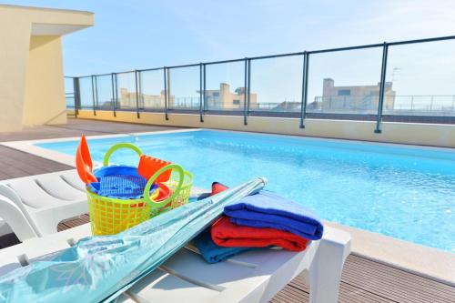 a swimming pool with a table with a basket of toys and a swimming pool at FLORIPES LUXURY APARTMENT with Pool on Rooftop in Olhão
