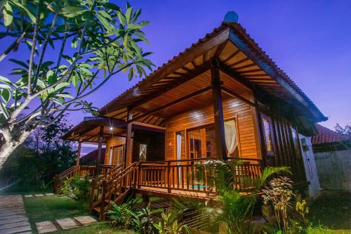 a cabin in the woods with a porch at Pondooks Joglo in Nusa Lembongan