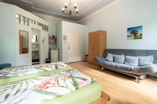 1 dormitorio con 1 cama y 1 sofá en Pension Primavera, en Viena