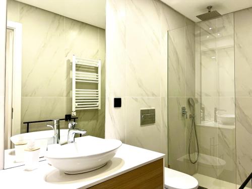Un baño blanco con lavabo y ducha. en Classy & Modern apartment Cascais, en Cascais