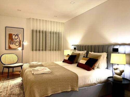 Un dormitorio con una cama grande y una silla. en Classy & Modern apartment Cascais, en Cascais
