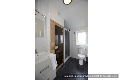 a bathroom with a tub and a toilet and a sink at Camping Loodsmansduin in Den Hoorn