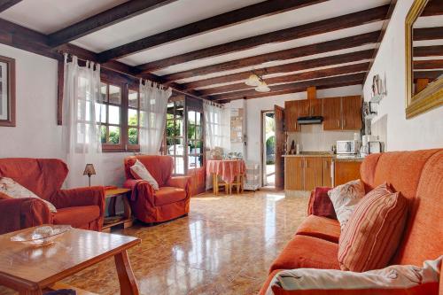 a living room with orange couches and a table at Casa Albryna Lanzarote in Tahiche